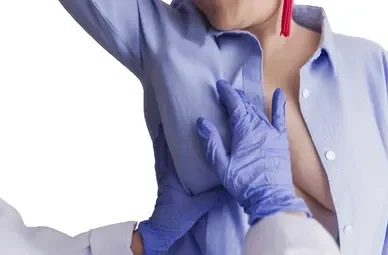 Healthcare worker in gloves administering a vaccination to a woman's upper arm.